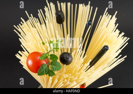 Materie spaghetti con pomodoro e olive poste in forma a spirale pronti per la cottura Foto Stock