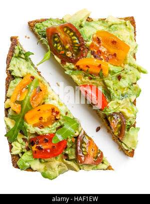 Fetta di pane di segale con avocado e colorati di pomodori e foglie aragula Foto Stock