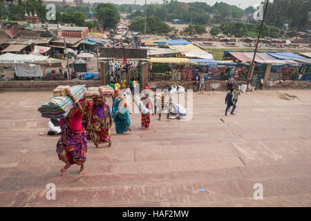 Il mercato come si vede dalle fasi di Jami Masjid moschea, Delhi, India, con persone che trasportano merci acquistate. Foto Stock