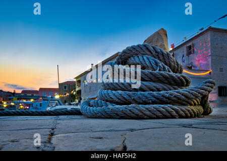 Avvolto in barca sulla corda mooring bollard vista serale, villaggio mediterraneo Foto Stock