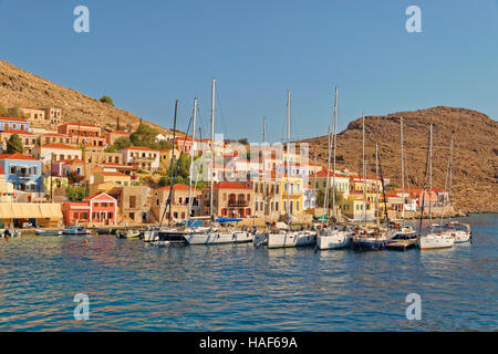 Yacht posti barca presso la città di Chalki, isola greca di Chalki situate al largo della costa nord di RODI, DODECANNESO Isola Gruppo, Grecia. Foto Stock