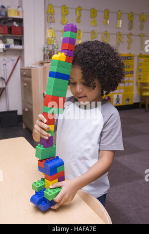 Giovane ragazzo costruisce una torre con blocchi di Lego presso una scuola materna a Manhattan sul Lower East Side. Foto Stock