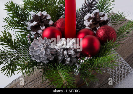 Decorazione di natale con ornamenti di rosso e argento pigne. Centrotavola di natale con argento perle. Foto Stock