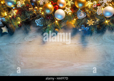 Natale abete con luci su sfondo di legno nel buio. Buon Natale e Felice Anno Nuovo!! Vista dall'alto. Foto Stock