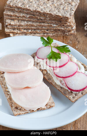 Panini con salsiccia e ravanelli su sfondo di legno Foto Stock