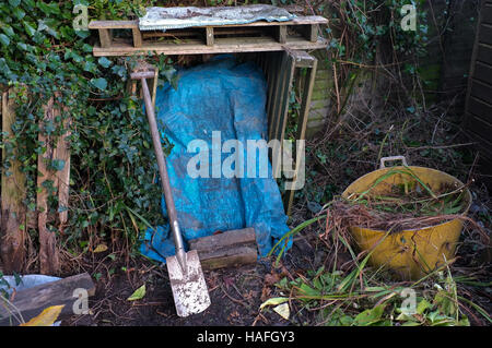 Un mucchio di composto coperto con un foglio di plastica per evitare la pioggia di salire in Foto Stock