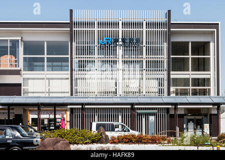 Giappone, Tatsuno. JR, Japanese railway station, Hon-Tatsuno. Esterno di due-storia edificio moderno con un esterno scende e taxi lane. Blue sky. Foto Stock