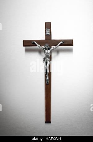 Argento e il crocifisso in legno su un sfondo di metallo con il corpo di Cristo sulla croce, vignette e spazio di copia Foto Stock