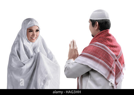 Musulmani asiatici l uomo e la donna salutarci con la tradizione musulmana isolati a sfondo bianco Foto Stock