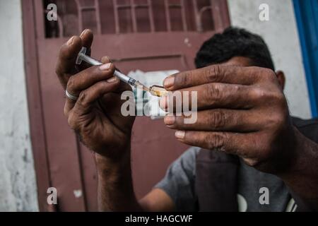 Il nord di Sumatra, Indonesia. 30 Novembre, 2016. Un farmaco eroina utente tiene una siringa in un parco a Medan di Nord Sumatra, Indonesia, nov. 30, 2016. © Albert Damanik/Xinhua/Alamy Live News Foto Stock
