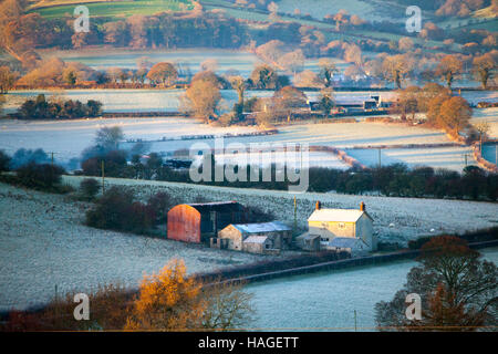 Sunrise colpisce una piccola azienda nel villaggio di Rhes-y-CAE in Flintshire, il Galles del Nord con la gamma Clwydian nella distanza Foto Stock