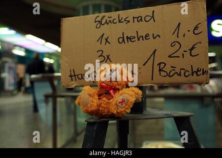 (161201 ) -- FRANCOFORTE, 1 dicembre, 2016 (Xinhua) -- un giocattolo orso con un nastro rosso per la donazione si siede a un consulente del supporto per il mondo?AIDS?il giorno a una stazione della metropolitana a Francoforte, Germania, dal 1 dicembre 2016. (Xinhua/Luo Huanhuan) Foto Stock