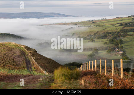 La vista da Barcombe Hill, sede di un forte collinare dell'età del ferro e della Long Stone, con la bassa nebbia aggrappata al Foto Stock