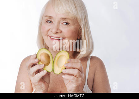 Bella donna piacere mettere le due metà di avocado insieme Foto Stock