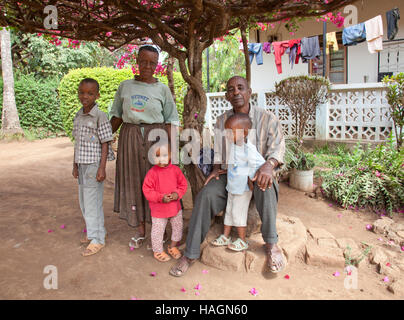 Famiglia africana in Tanzania davanti alla loro casa in bambini rurali in Tanzania,Africa a giocare e lavorare divertendosi Foto Stock