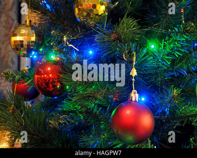 Colorate luci colorate stagionale sul decorazioni di Natale dare festosa rosso verde oro e blu Foto Stock