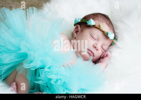 Ritratto di neonato adorabile bambina in teal tutu dormire sulla pelliccia bianca. Foto Stock