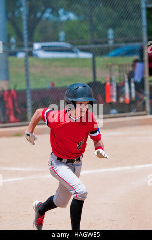 I giovani adolescenti kid baseball in esecuzione per la prima base. Foto Stock