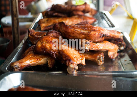 Pollo alla griglia, stile tailandese e in un vassoio sul cibo di strada stallo per la vendita. Foto Stock
