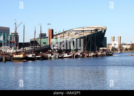 Science Center NEMO Oosterdok al porto di Amsterdam, Paesi Bassi. Vecchie barche a vela ormeggiata davanti. Foto Stock