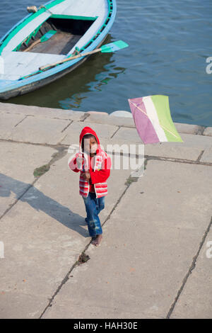 VARANASI, India - 4 gennaio 2015 : Boy volare un aquilone sulle rive del Gange Foto Stock