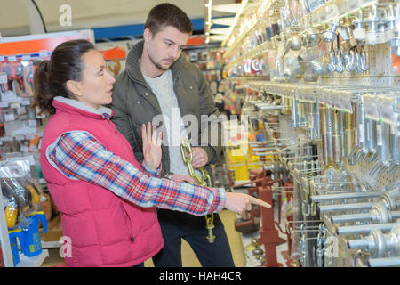 Bella commessa hardwarestore aiutando il cliente Foto Stock