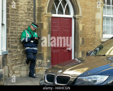 Un vigile emette un biglietto di parcheggio a Stamford Inghilterra REGNO UNITO Foto Stock