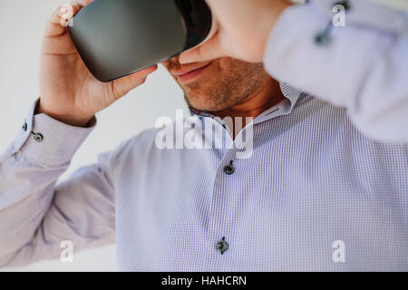 Closeup colpo di giovane uomo utilizzando occhiali per realtà virtuale. Imprenditore indossando occhiali VR. Foto Stock