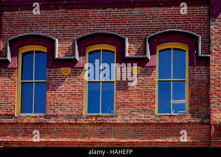 Tre finestre sull'esterno di un edificio in mattoni Foto Stock