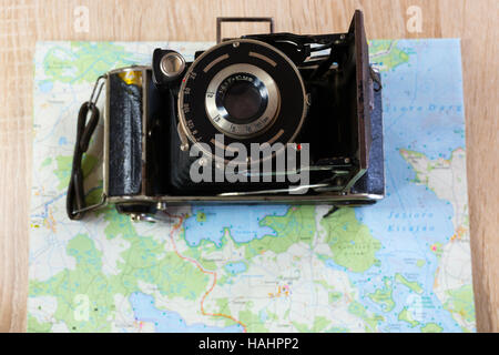 Vecchia macchina fotografica su una mappa di laghi in Polonia. Fotocamera obsoleta su una mappa. Foto Stock