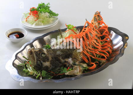 Dentice al vapore pesce cernia con la carota e la cipolla sul piatto da portata Foto Stock