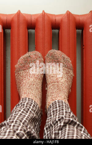 Piedi con calze di lana riscaldamento su radiatore Foto Stock