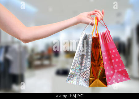 Donna con le borse della spesa in negozio di abbigliamento Foto Stock