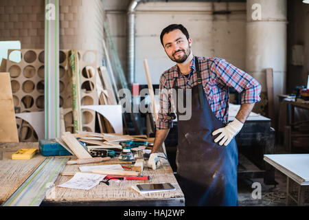 Carpenter operando con cautela guardando i piani Foto Stock