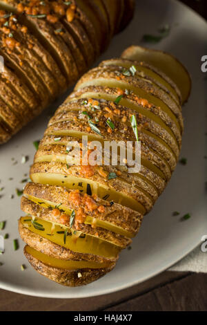 In casa Cheesy Hasselback patate con erbe fresche Foto Stock