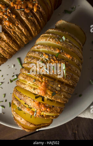 In casa Cheesy Hasselback patate con erbe fresche Foto Stock