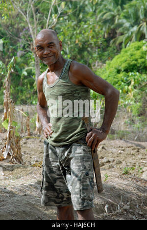 Un agricoltore con la sua geniale nel suo le risaie, Lawigan, San Joaquin, Iloilo, Filippine. Foto Stock