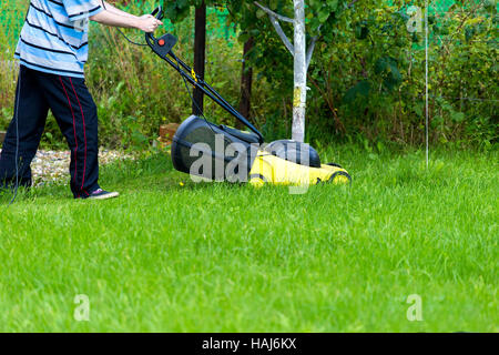 Giovane giardiniere con tosaerba Foto Stock