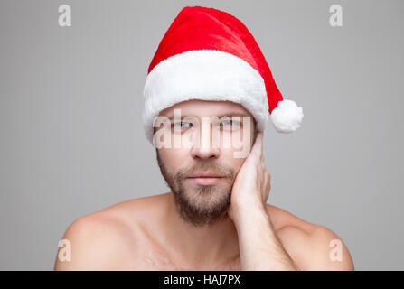 Ritratto di un uomo bello con la barba che indossa un cappello di Natale Foto Stock