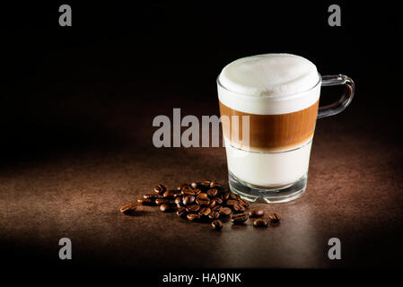 Un bicchiere di latte caldo macchiato caffè close up Foto Stock