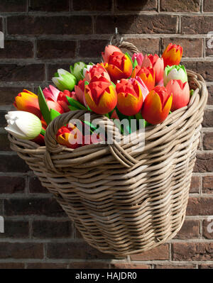 Cesto in Vimini piena di colorati tulipani in legno Foto Stock