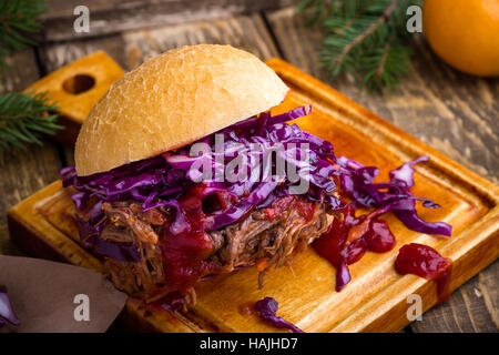 In casa barbecue hamburger di manzo con croccante di cavolo rosso slaw sul tavolo rustico. Barbecue sandwich a base di carne per il pranzo di natale Foto Stock