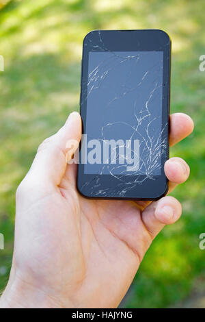 Smartphone con schermo rotto in mano Foto Stock