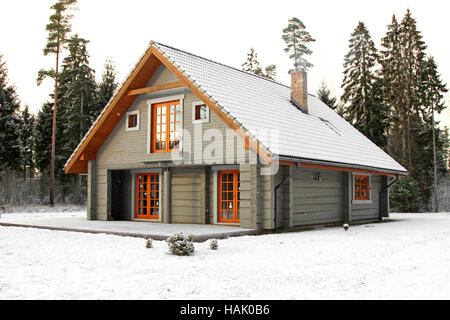 Snowy legno lodge in foresta Foto Stock