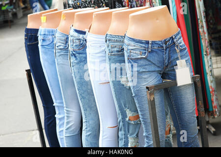 Fila di manichini con differenti jeans nel marketplace Foto Stock