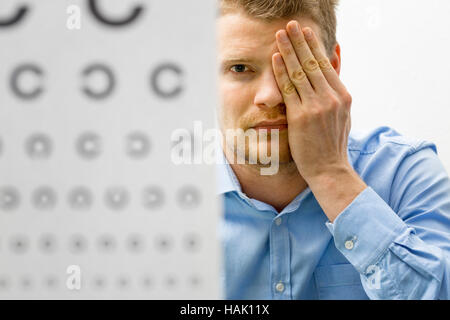 Controllo della vista. paziente di sesso maschile sotto visione esame Foto Stock