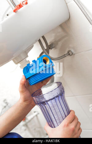 Plumber installazione di nuova acqua sistema di filtrazione Foto Stock