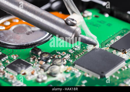 Macro shot di ferro di saldatura e il circuito stampato Foto Stock