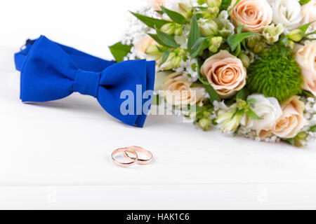 Gli anelli di nozze e accessori su bianco tavolo in legno Foto Stock