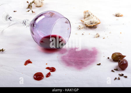 Macchie sulla tovaglia di fuoriuscite di vetro del vino e cibo Foto Stock